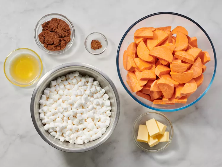 Ingredients for sweet potato casserole, including sweet potatoes, butter, brown sugar, eggs, milk, and marshmallows