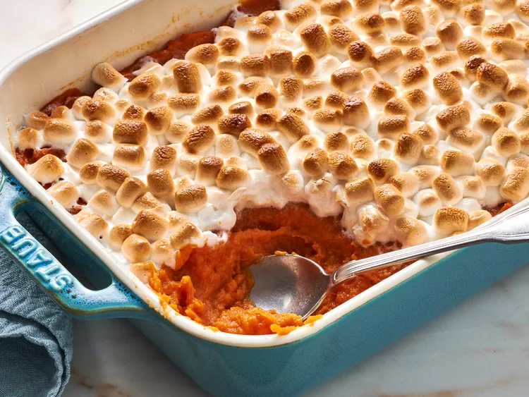 Ingredients for sweet potato casserole, including sweet potatoes, butter, brown sugar, eggs, milk, and marshmallows.